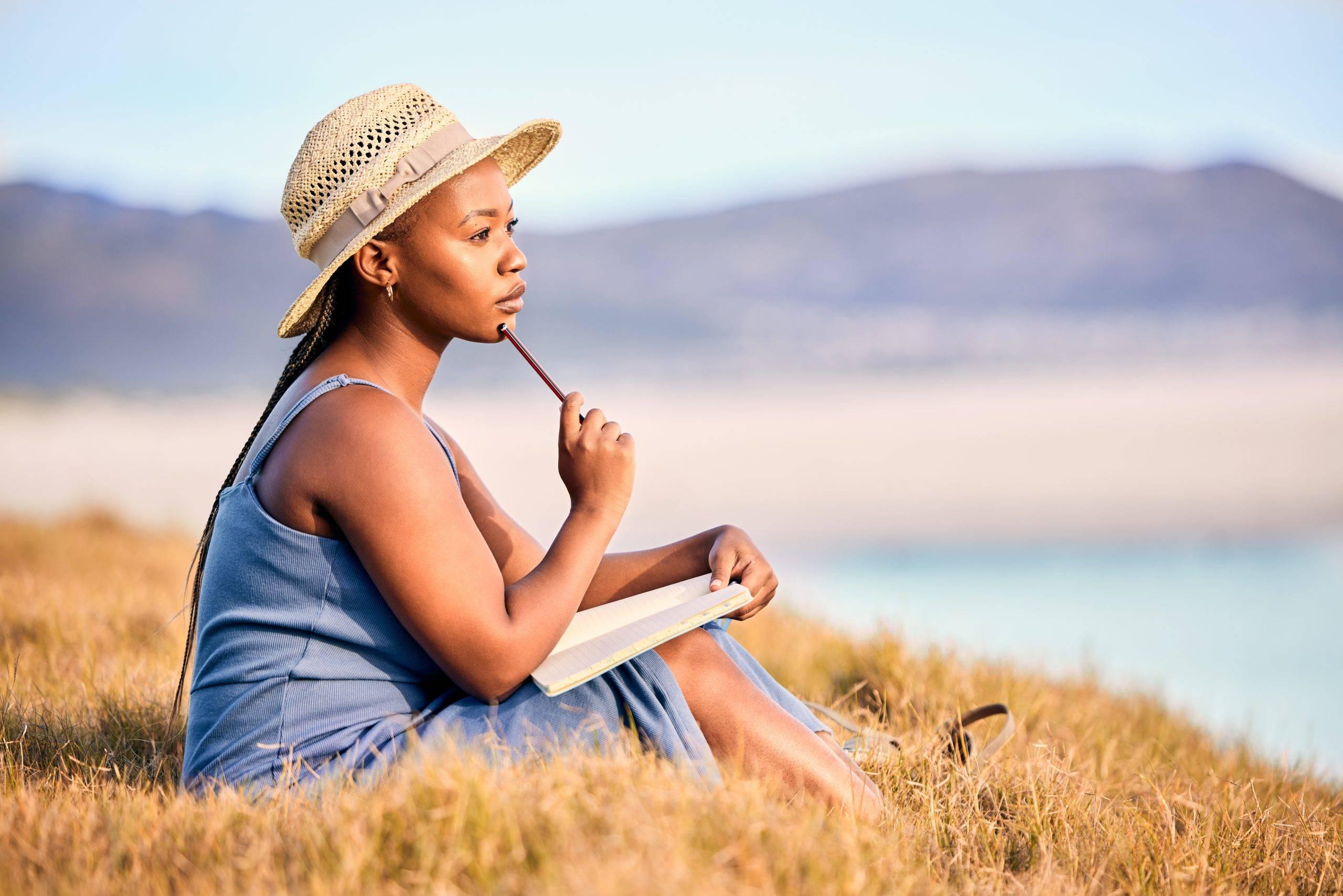 A woman sitting alone and journaling to get rid of negative thoughts.