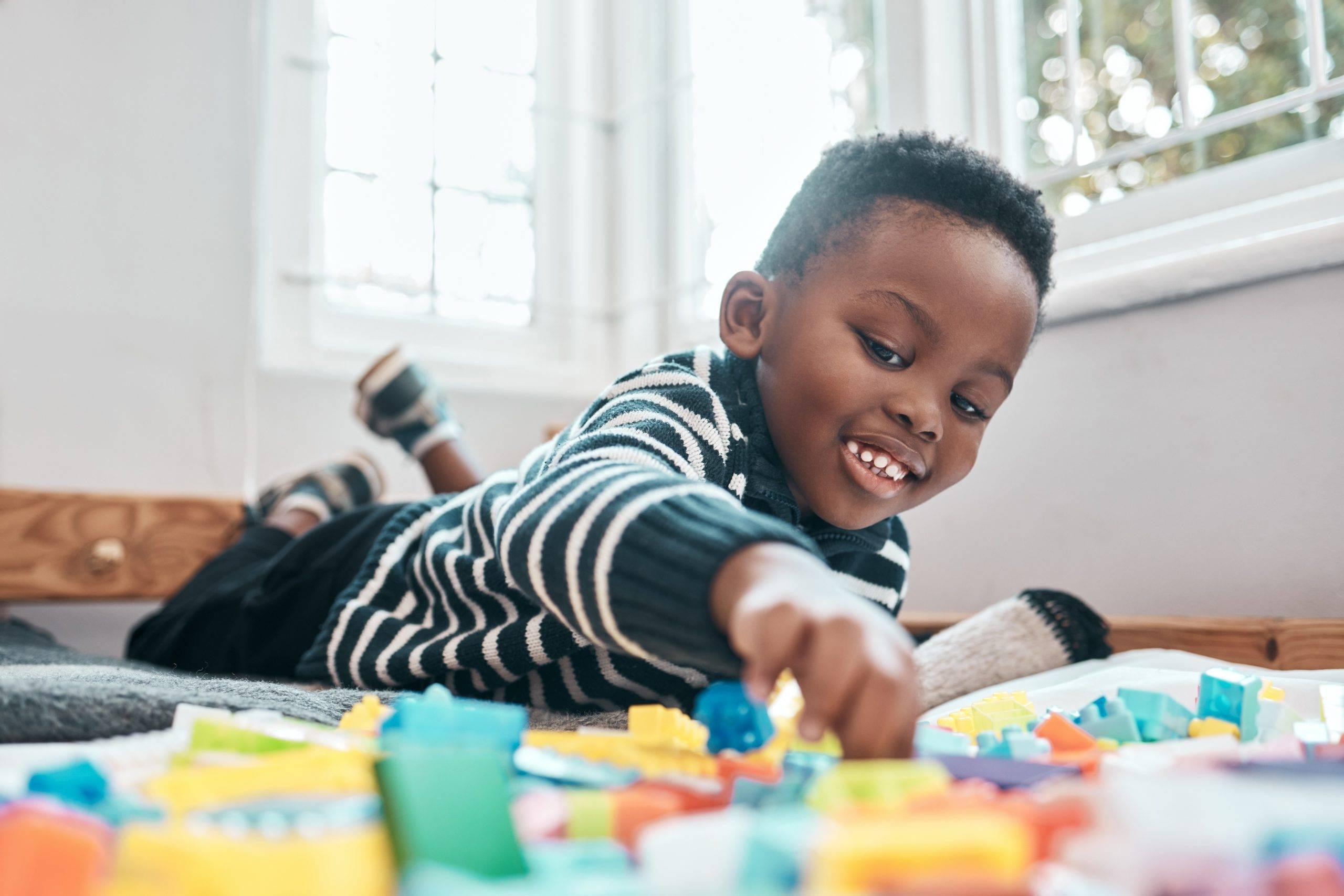 Shot of an adorable little boy playing with building blocks at home.