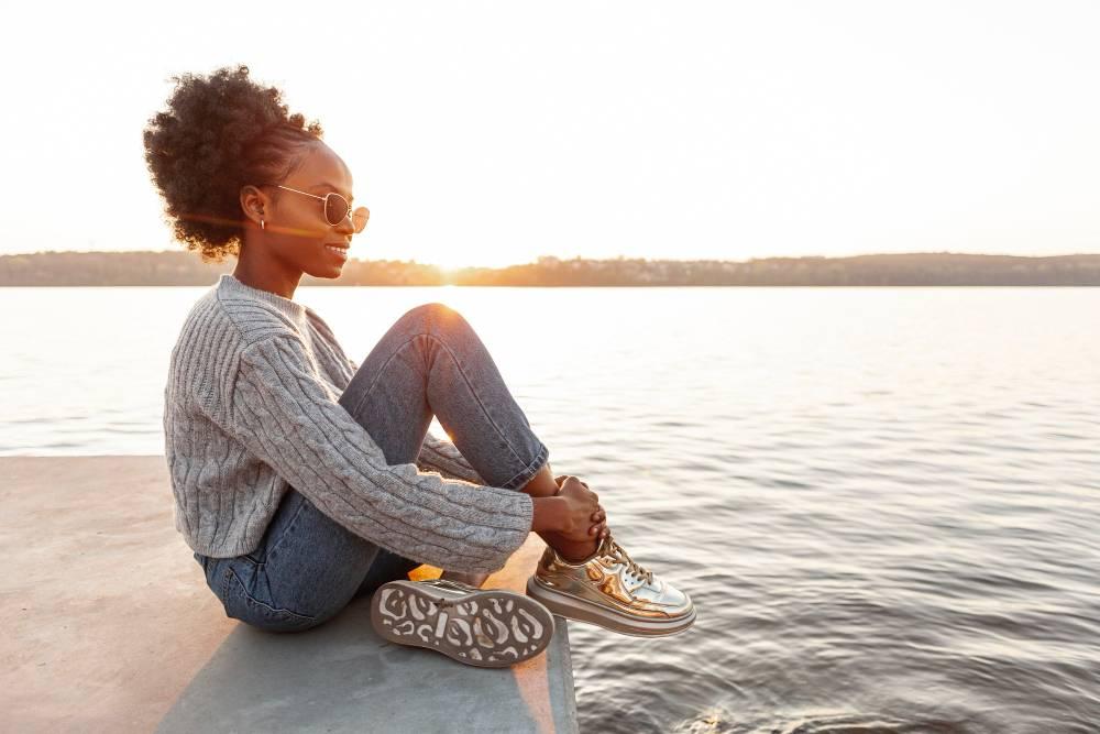 woman practicing selfcare by the ocean